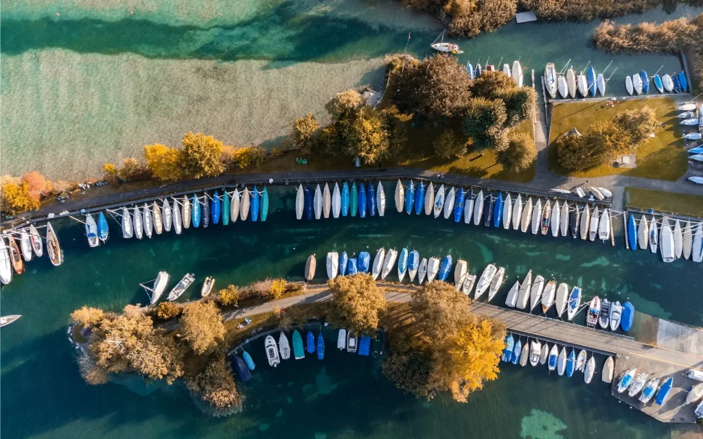 Bootshafen am Thunersee von oben, die Boote liegen in langen Reihen am Steg.